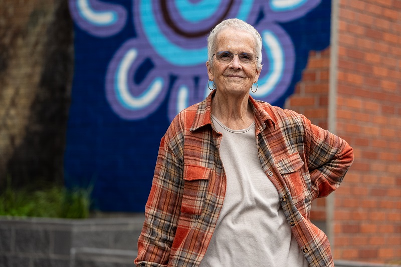 Image of renter next to the artwork wall with beautiful smile