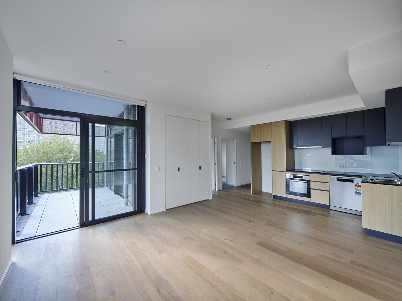 Image of indoor area having modern kitchen and living with balcony attached to the living room