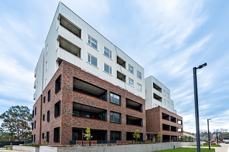 Image of Social housing building located along Kitchner Street, Brunswick  West.having red bricks and bi windows surrounded with greenery.