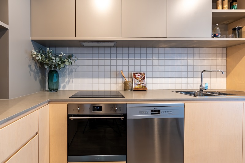 Image of Kitchen area with electric cook top, dishwasher and ample storage