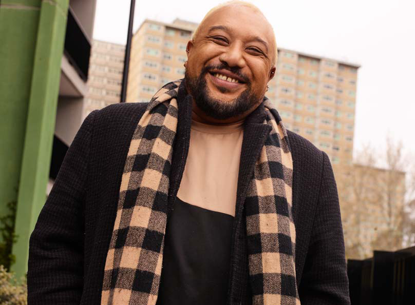 A renter smiling in front of apartment building