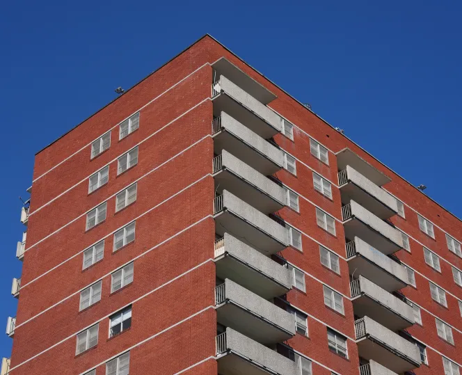 Red brick apartment building with blue sky in the background