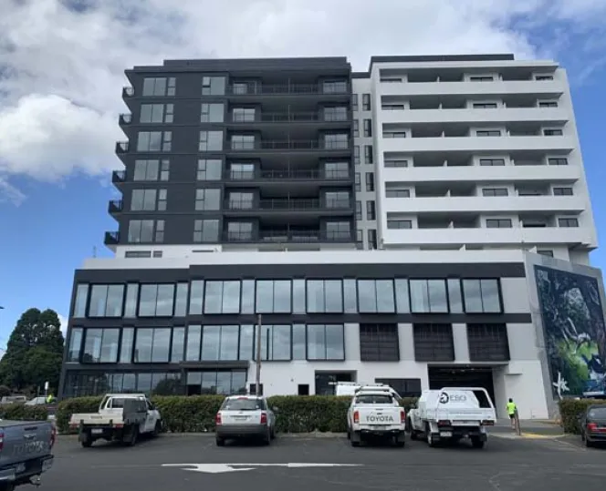 Image of apartment building with cars parked in front