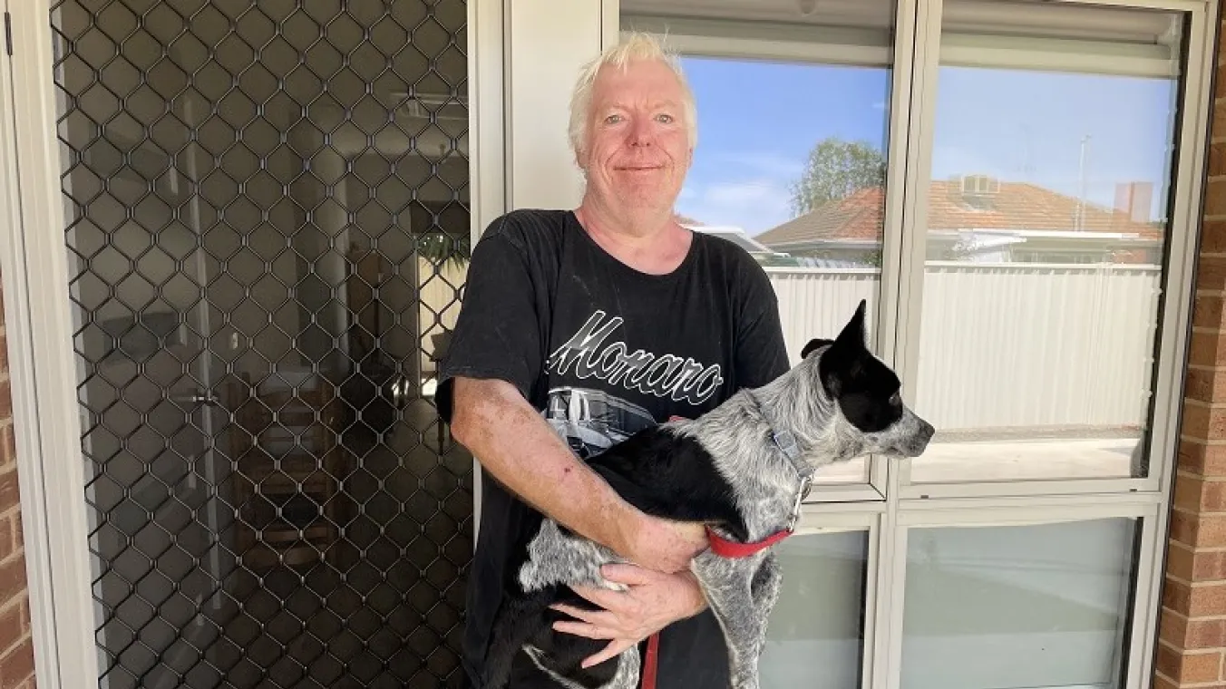 Image of resident moved into the new home and holding the dog